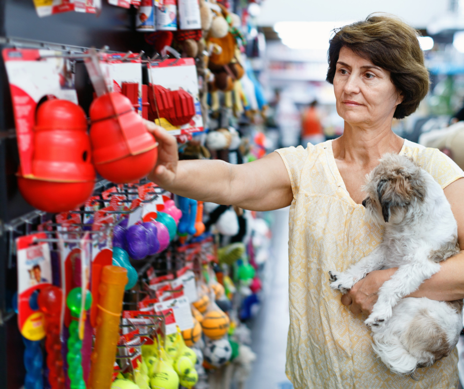 Lady in Pet Store Holding a Dog Exploring the Dog Products